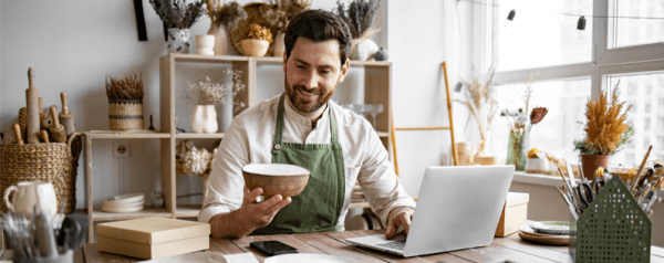 pottery shop owner working on laptop